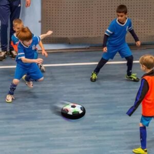 Children playing soccer with a hover ball outdoors