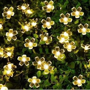 Flower LED string lights illuminating a garden at night.