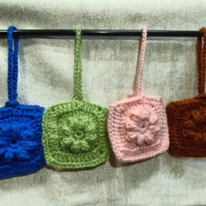 Handmade colorful crochet AirPods case bag charm with a soft knitted sleeve designed to protect wireless earbuds while adding a stylish handmade accessory.
